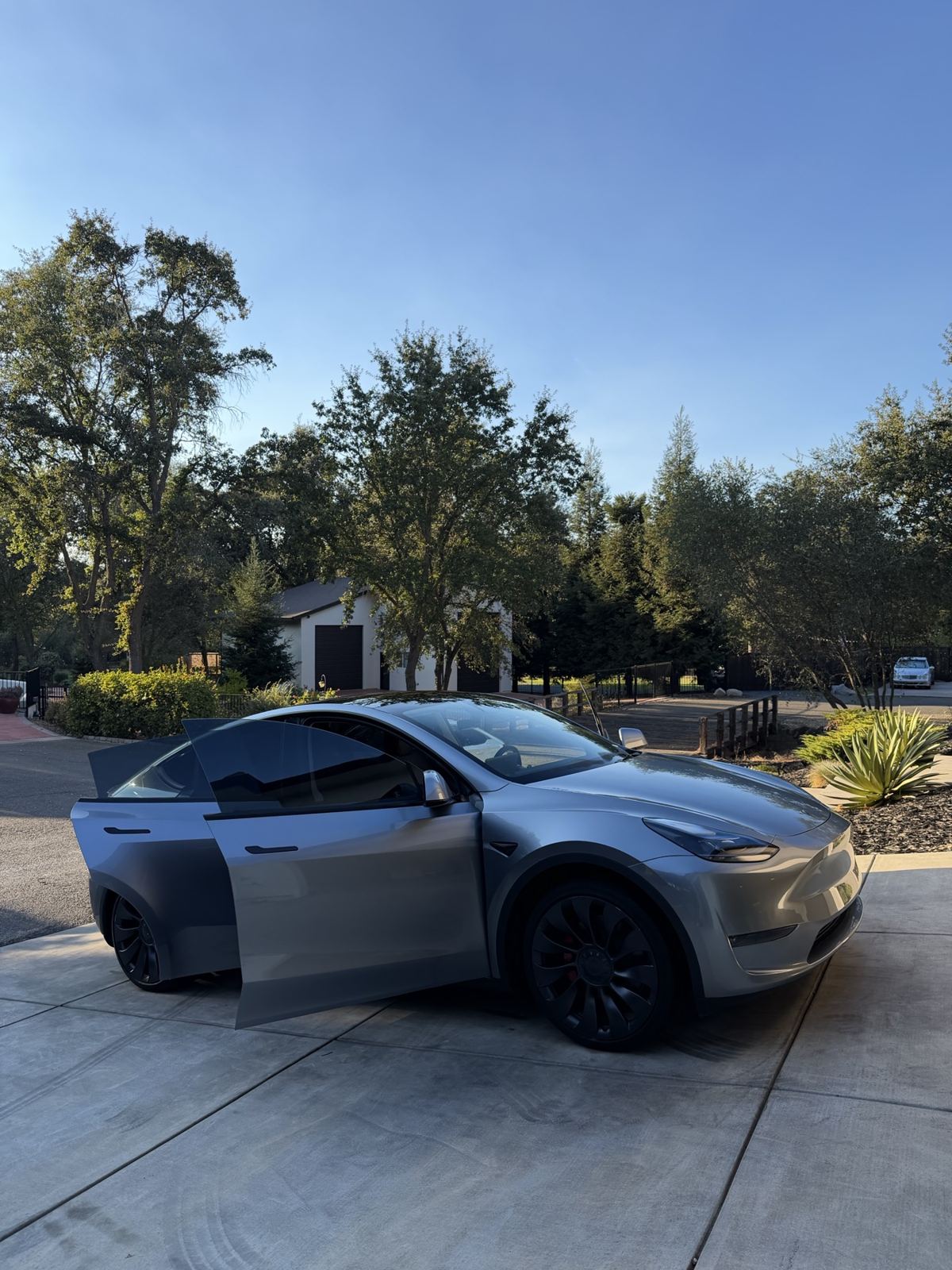A customer’s gray crossover after detailing in a residential driveway